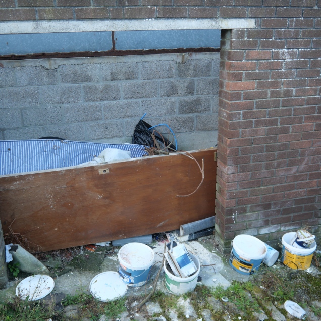 The rubbish dumped in the storage area that once held bins has been there for months